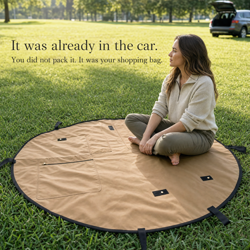 The Sunday Carry mat opened flat on grass beside an open car boot, with a woman sitting on it.